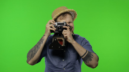 Portrait of man tourist photographer is taking photos on camera. Chroma key