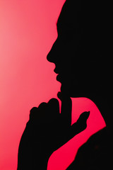 Naklejka na ściany i meble silhouette of thoughtful girl with arm under chin, unrecognizable woman face profile on red background,, concept life problems, anxiety,destructive emotions