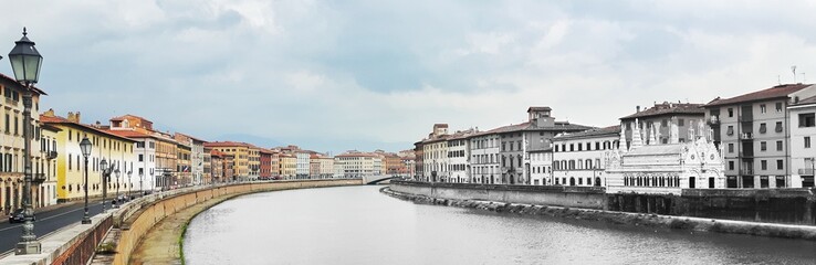 Fototapeta na wymiar Río Arno pasando por Pisa rodeado de bellas casas de la época