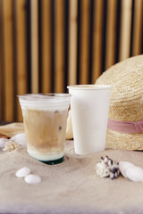 tasty coffee and frappuccino on a sand beach