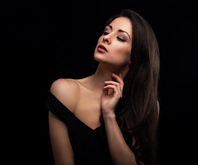 Beautiful makeup sexy woman with long hair looking sensual with elegant hand and fingers near the neck on black background. Closeup portrait. Art.Expression portrait.