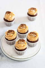 Homemade chocolate dough cupcakes with peanut butter frosting and snickers bites. Selective focus