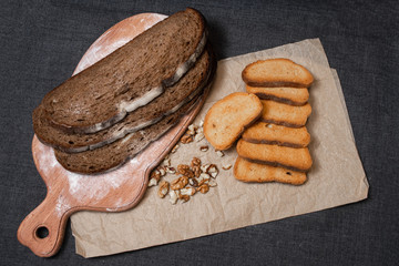 Baking, dark bread, cookies and rolls on a dark background.
Kraft paper. Milk in a transparent glass.