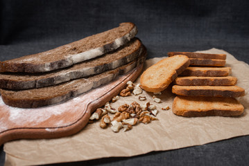 Baking, dark bread, cookies and rolls on a dark background.
Kraft paper. Milk in a transparent glass.