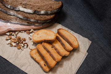 Baking, dark bread, cookies and rolls on a dark background.
Kraft paper. Milk in a transparent glass.