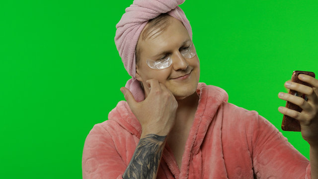 Portrait of transsexual man in bathrobe making selfies using mobile phone