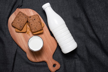 Bottle of milk, cookies on a dark background
