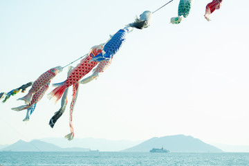 Carp streamers hanging on string over sea