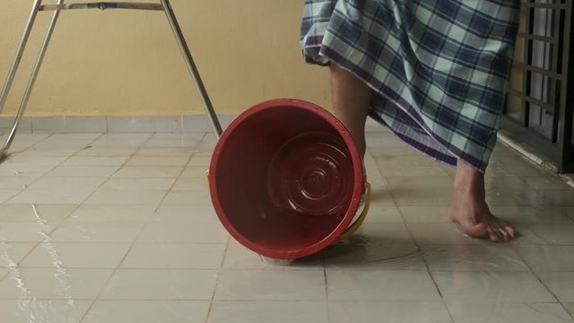 A footage of leg kick the bucket during floor cleaning.