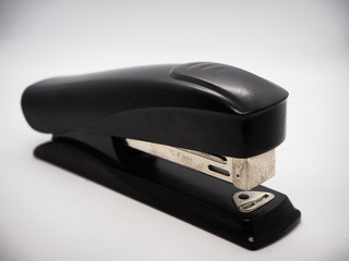 Black stapler on white surface