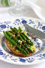 Vegan whole grain bread sandwich with asparagus, pea puree, nuts and soy sauce.