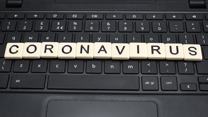Coronavirus on computer keyboard. Wide screen aspect ratio.