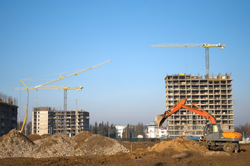 Bucked wheel excavator digs ground at a construction site for installing concrete storm pipes....