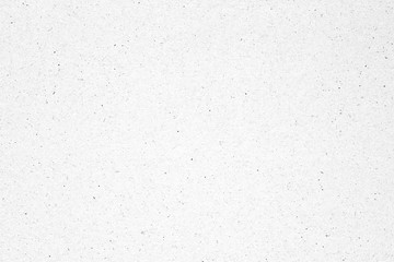 White paper or cardboard texture background with black spot.