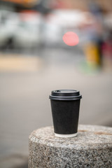 Cup of coffee on bench on the city street town coffeebreak daylight bokeh