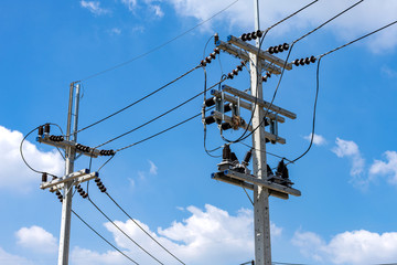 High voltage cables with electrical insulator and equipment on concrete electric pole.