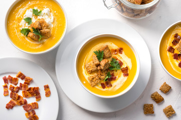 Butternut squash cream soup with milk cream, bacon, croutons, feta cheese and parsley