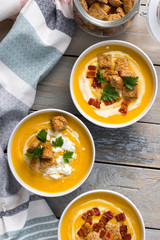 Butternut squash cream soup with milk cream, bacon, croutons, feta cheese and parsley