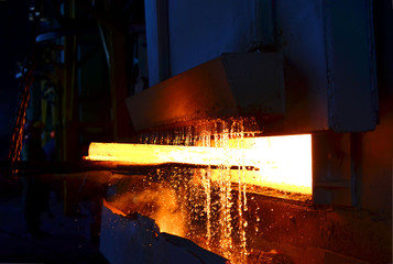 Steel quenching at high temperature in industrial furnace at the workshop of a forge plant. Process...
