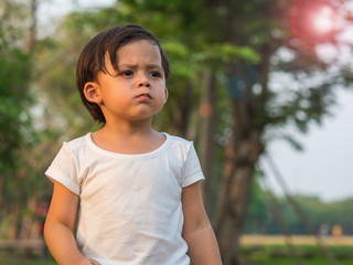 Cute little boy looking determined, looking in front in the park.