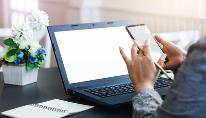 Close-up of businesswoman working at home with laptop and use smartphone to searching information online, Concept work from home