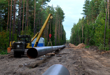 Natural gas pipeline construction work. A dug trench in the ground for the installation and installation of industrial gas and oil pipes. Crawler crane bulldozer with side boom or pipelayer