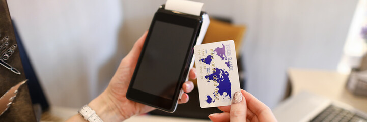 Close up female hands holding credit card reader