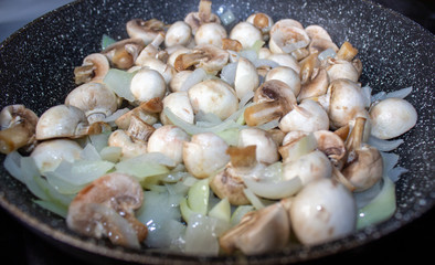 Fototapeta na wymiar Mushrooms with onions in a frying pan. Preparing lunch and dinner.