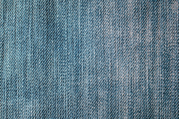 Blue denim texture with slight scuffing, taken close-up