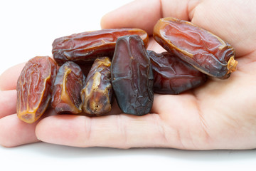 Hand holding  pitted dates isolated on white background
