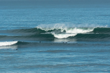 Surfers prepare to surf as the waves break