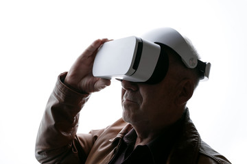 Old man using VR helmet on white background. Male in glasses of virtual reality. Augmented reality, game, future technology concept. VR. Free space for text.