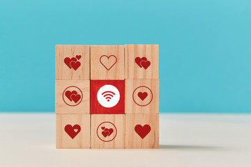 Square of wooden cubes with hearts and wifi signs. Online dating. Virtual communication and relationship, copy space