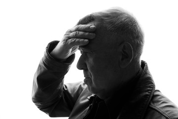 Old man holds his head. Aged male feeling sick, having headache. Black and white.