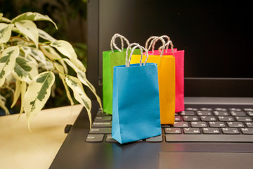 online shopping concept. little colorful shopping bags stand on laptop. copy space