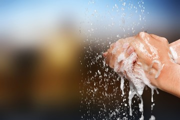Man washing hands in clean water on blur background