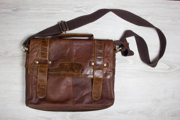 men's clothing worn wooden backgroundbrown leather men's bag. men's clothing worn wooden background
