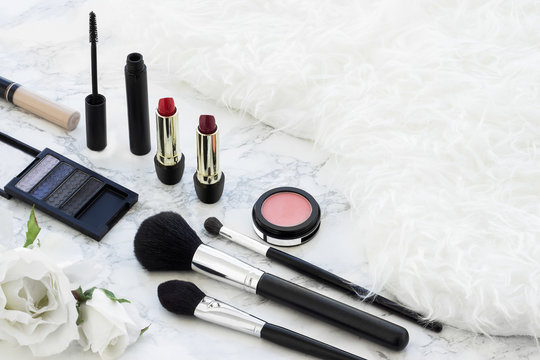 Fashion make up products in a white fur texture background