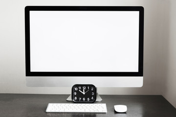 Working place, clock and computer with keyboard on a dark table in the office. Business and...