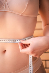 Young woman measuring her waist. Health and beauty concept. Selective focus