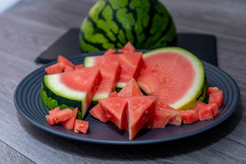 Plate with tasty sliced watermelon on table