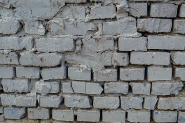 Beautiful white painted brick wall shabby old with cracks in the loft style with seams. Texture, background