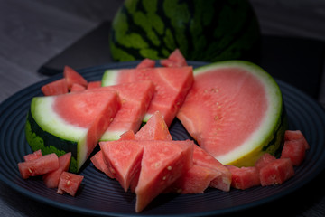 Plate with tasty sliced watermelon on table