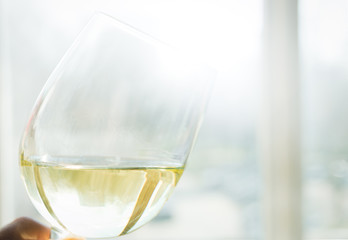 glass of white wine in female hand, selective focus
