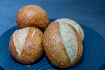 A few freshly baked bread rolls on dark background