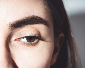 Beautiful female eye. One brown eye close-up. The eye is looking down. Mascara on the eyelashes....