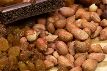 Peanut, sultana raisins, chocolate bar background close up. On wooden background