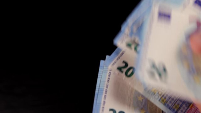 Man counting countless pack of twenties on black background fast-paced footage. Money concept. Wealth concept.