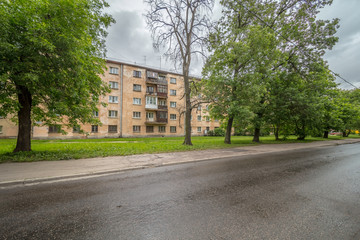 Old apartment house on green meadow in summer