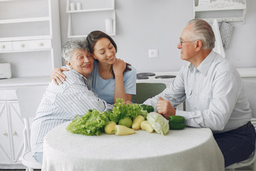 Family in a kitchen. Grandparents with granddaughter. Family made a salad
